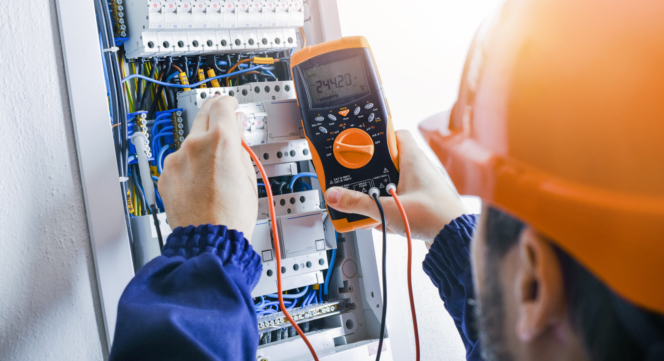 Multimeter in hands of electricians detail.